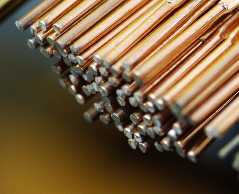 Close-up of a bundle of thin copper wires with a reflective surface.